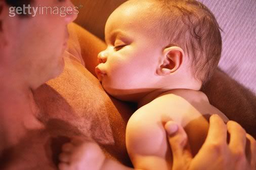 Shirtless daddy holding sleeping baby